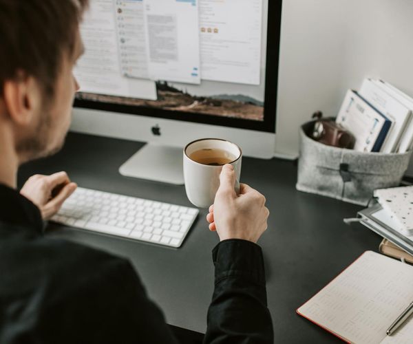 Person taking a mindful break to stretch by a window in their office.